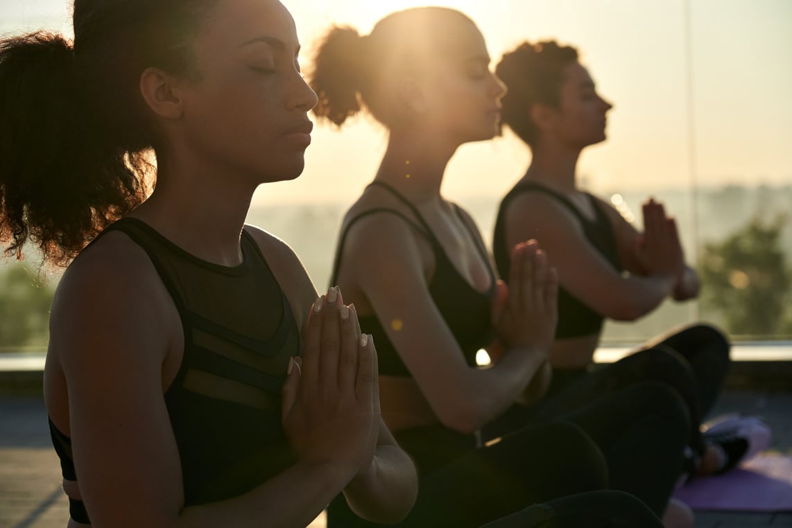 Women Meditating at Outdoor Group Yoga Class.